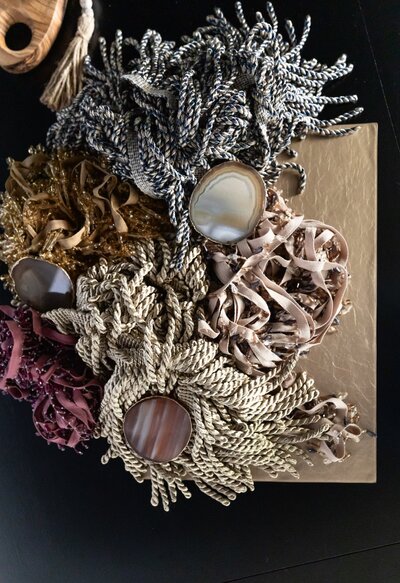 Detailed interior design selections including agate medallions and luxury trim tassels laid out for client presentation.