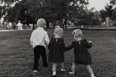 A group of little children and siblings walking holding hands together 