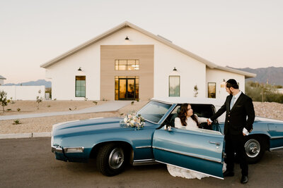 newlyweds pose with vintage car