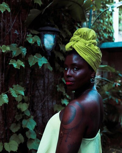 Pictured woman in nature, headwrap. Joyell Johnson, owner of the Mangrove Midwife
