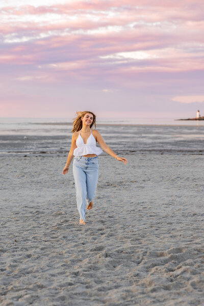 Photo of senior girl on the beach running toward the camera during sunset