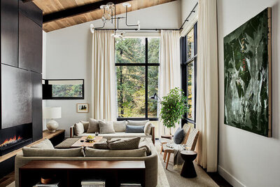 New England interior designers design a Vermont living room with modern furniture, warm wood ceilings, and curated fine art for a refined retreat.