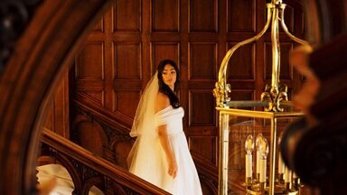 Bride dramatically walking down a grand staircase in Laurel Hall Wedding Venue