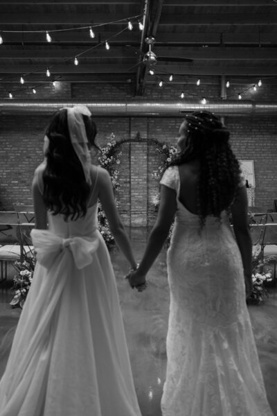 bride's mother helps button her wedding dress
