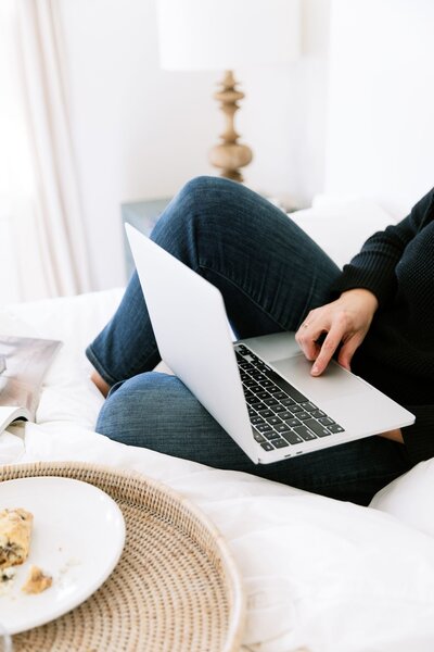 Showit website developer looking over her shoulder smiling while holding an iphone