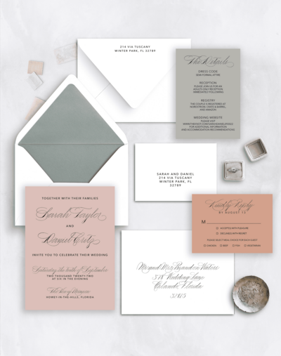 Flat lay of a warm-toned wedding invitation suite with