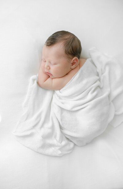 infant snuggled with blankets