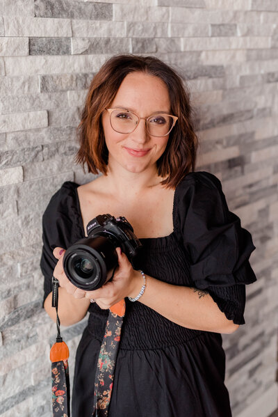 Woman poses for the camera with Nikon Z6II Camera in hand.
