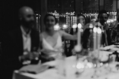 Bride and groom toast in a restaurant overlooking St. John's Harbour at night