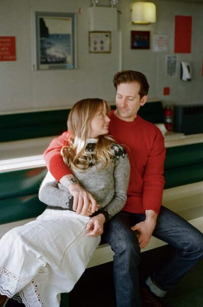 bride and groom cuddle on a retro ferry in Newfoundland