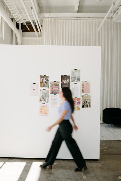 website designer walking by mood board in photo studio