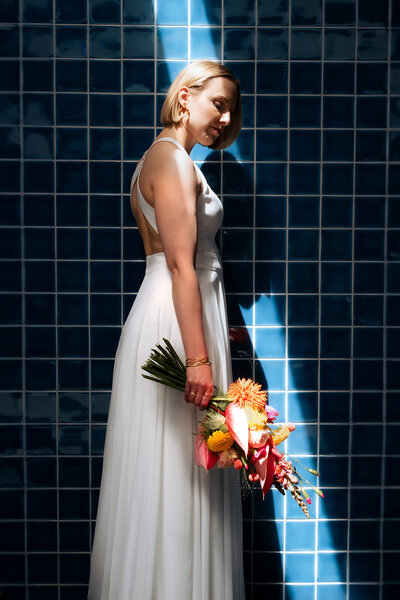 Hochzeitsfotograf in Karlsruhe. Braut artistisch fotografiert mit tollem Blumenstrauß vor der Ginas Bar im Hirschhof Karlsruhe