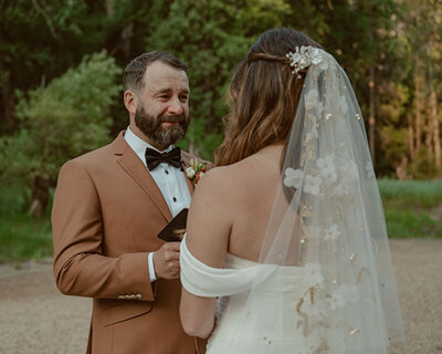 bride and groom exchanging vows at cathedral beach in yosemite; groom is crying