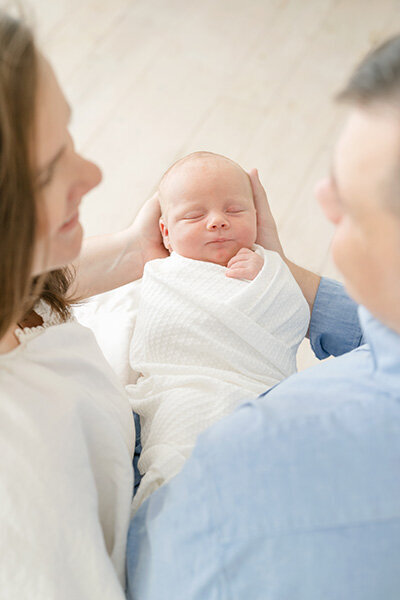 Happy, new parents smile at each other during newborn pictures with Julie Brock Photography in Louisville KY