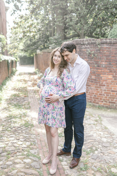 Man and pregnant woman in a cobblestone alley in Old Town Alexandria Virginia