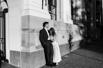 couple engaged walking city cbd christchurch photographer wedding suit yellow dress holding hands