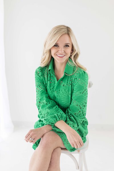 A blonde woman in a kelly green dress with a collar.