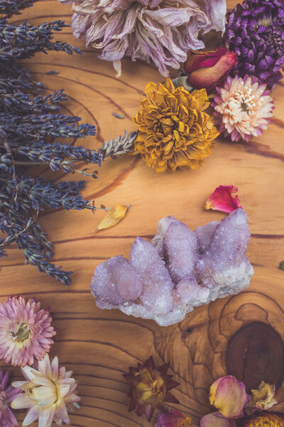 a spirit quartz cluster in a flat lay with dried blooms
