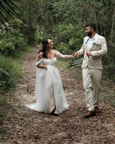 Eloping couple running through the trees