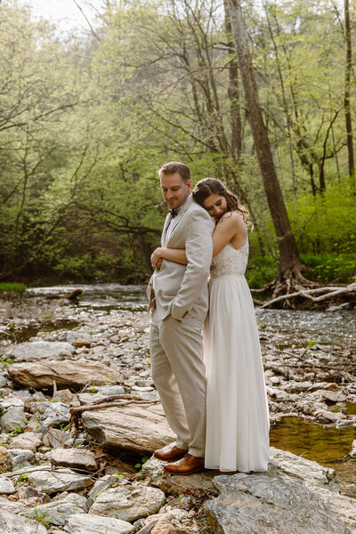 Two marriers look into one another's eyes in a forest.