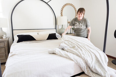 Professional cleaner making the bed