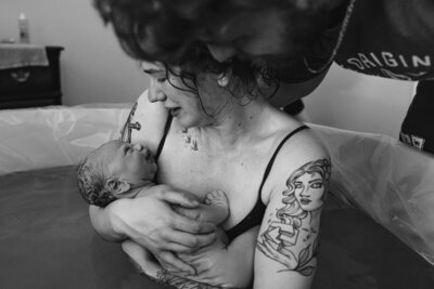 Photo of new mother holding newborn, home birth, doula