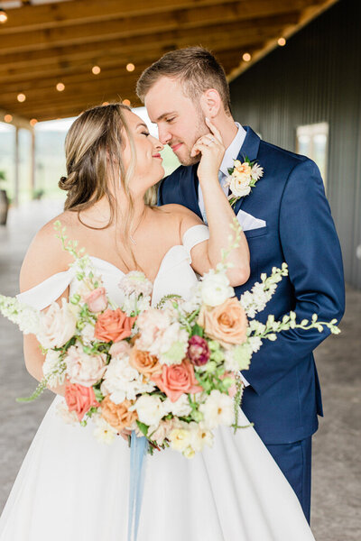 bride and groom embrace with bride holding bouquet