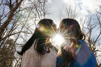 Lesbian Couple piggy back ride during their Engagement Photos with Tiny House Photo