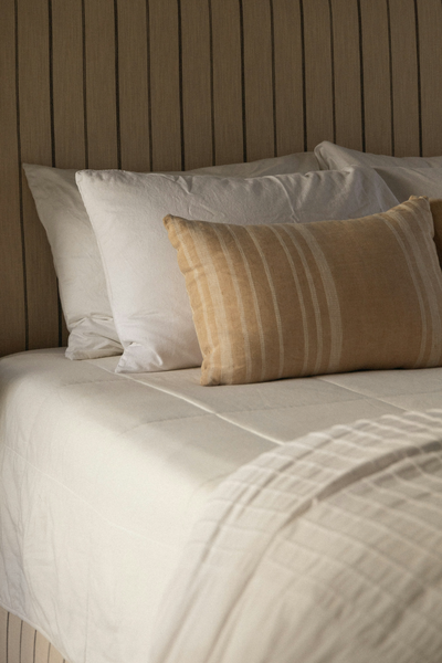 neutral bedding and textured throw pillow