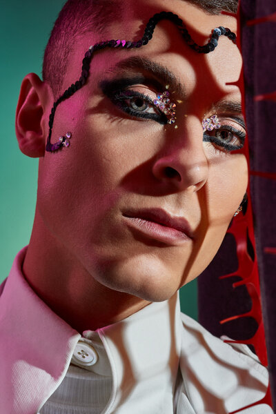 Artistic portrait of Cory with bold makeup and abstract styling, featuring a dramatic red accessory, photographed by Ylva Erevall.