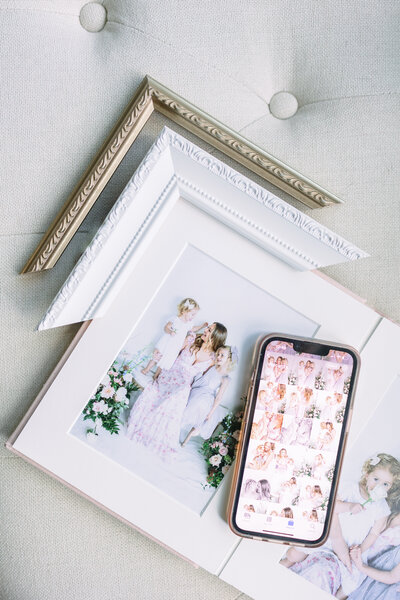 image of frame corners surrounding album with image of mom and her 2 daughters as well as cell phone holding digital images of the same photo
