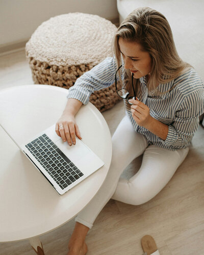 women sitting on floor on her laptop