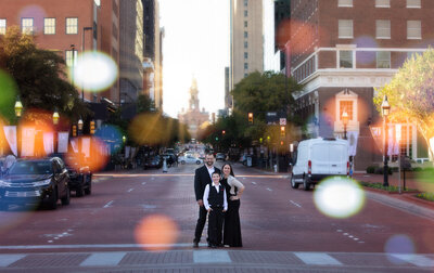 family-of-3-standing-in-crosswalk-in-downtown-fort-worth-wearing-formal-clothes