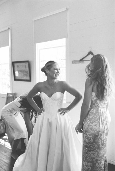 a bride getting ready, smiling at her sister