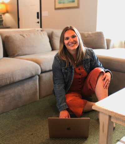 Kinsey, owner of Fresh Beginnigs, sits on the floor as she works on the computer.
