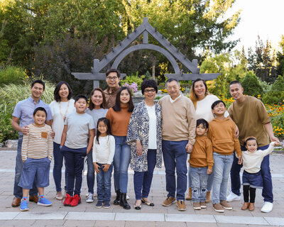 Large extended family portrait standing outdoors in park
