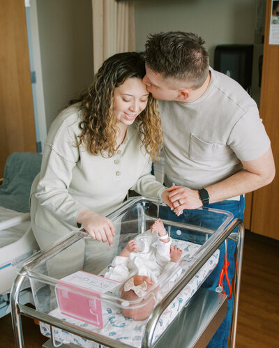 mom and dad by bassinet in the hospital