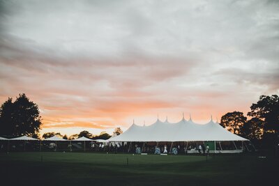 a tent wedding photographed at dusk