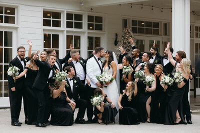 Wedding party cheers as the bride and groom share a kiss, surrounded by laughter and joy.