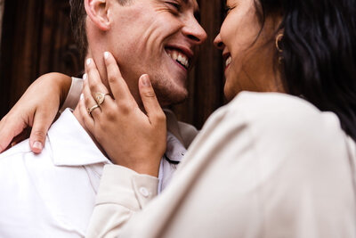 love in ostuni puglia man en vrouw in lichte kleren vrouw heeft arm om man en hand met ringen bij het gezicht