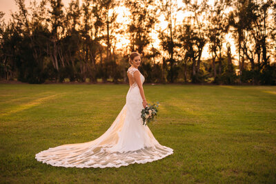 bride standing in field while holding  bridal bouqet