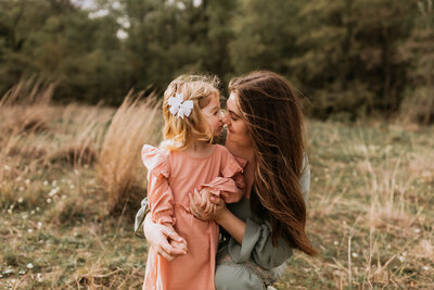 mom and daughter rubbing noses with windblown hair