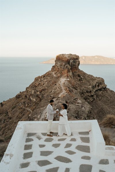 A couple who eloped in Santorini exchange their vows in front of Skaros rock