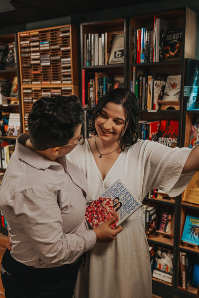 A couple looks at each other in the aisles of a bookstore
