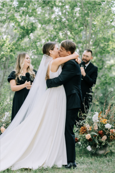 bride and groom kiss at wedding ceremony