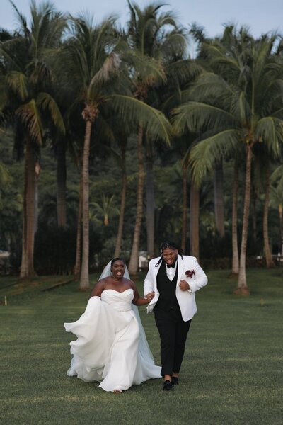 bride and groom run towards camera after destination wedding ceremony