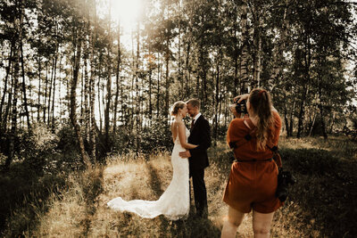 fotograf fotograferar brudpar under bröllop i skogen i halmstad