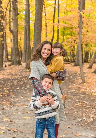 Mom in gray cardigan hugging her two young kids for their Chicago family photos in the fall by Kristen Hazelton