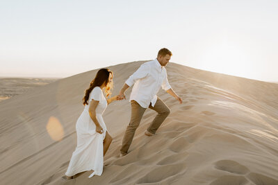 couple walking on the sand dunes