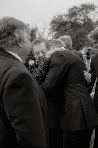 Black and white photo  of man hugging elderly lady